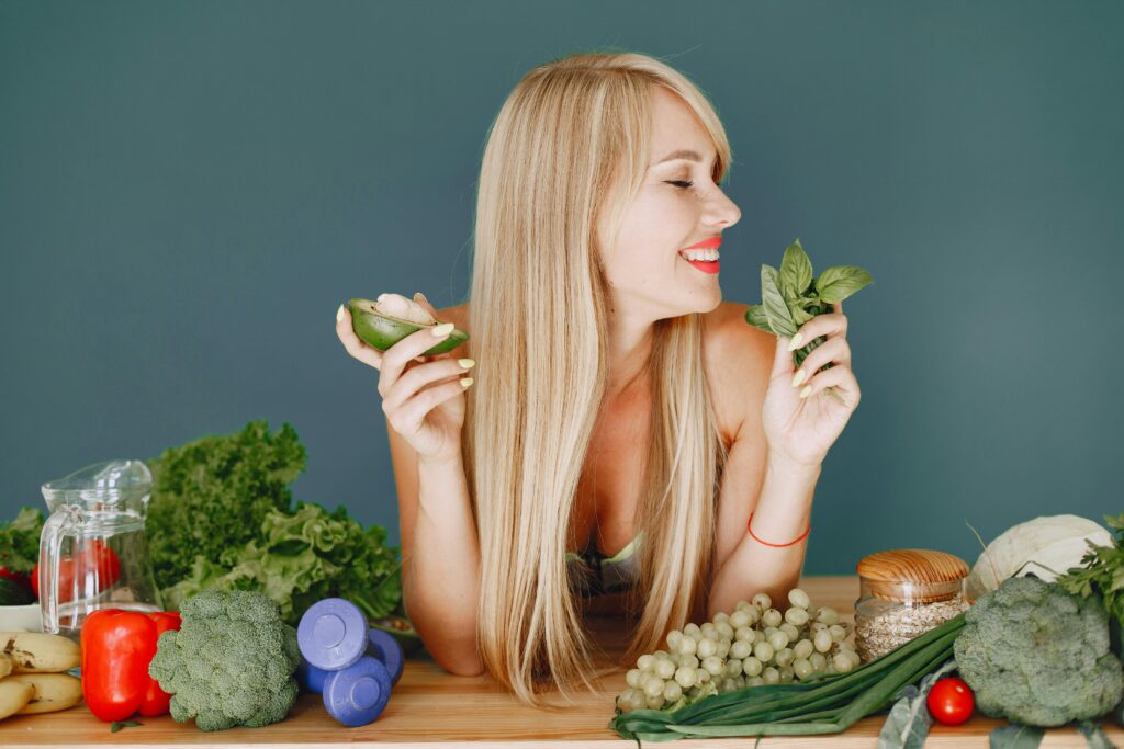 mulher jovem em sua cozinha, segurando uma tigela colorida de comida saudável com expressão leve, representando alimentação saudável e conveniente